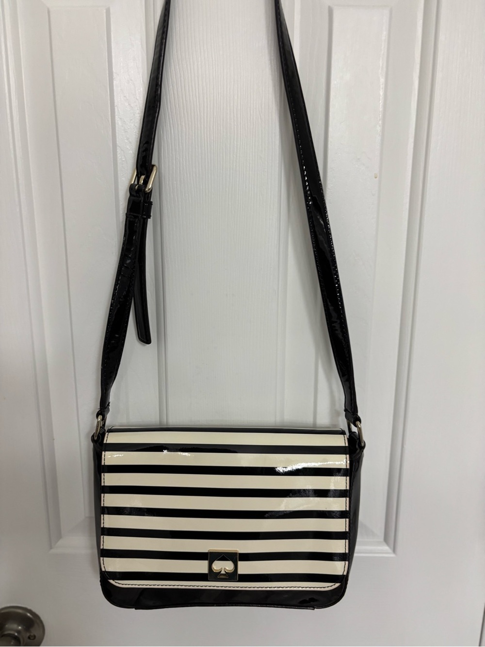 Kate Spade New York Black and White Striped Crossbody Bag with adjustable strap.